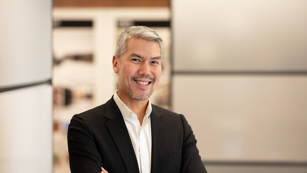 A man in a suit smiling.